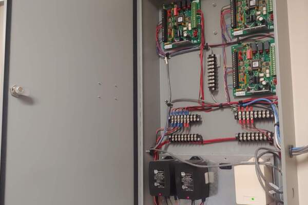 Access control panel with circuit boards and wiring inside an open cabinet