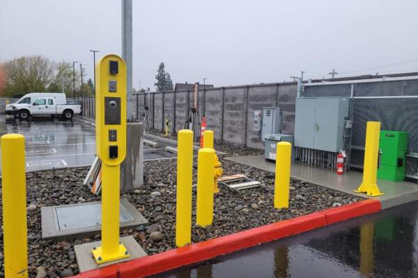 Yellow access control pedestal with card reader at a commercial parking lot entrance