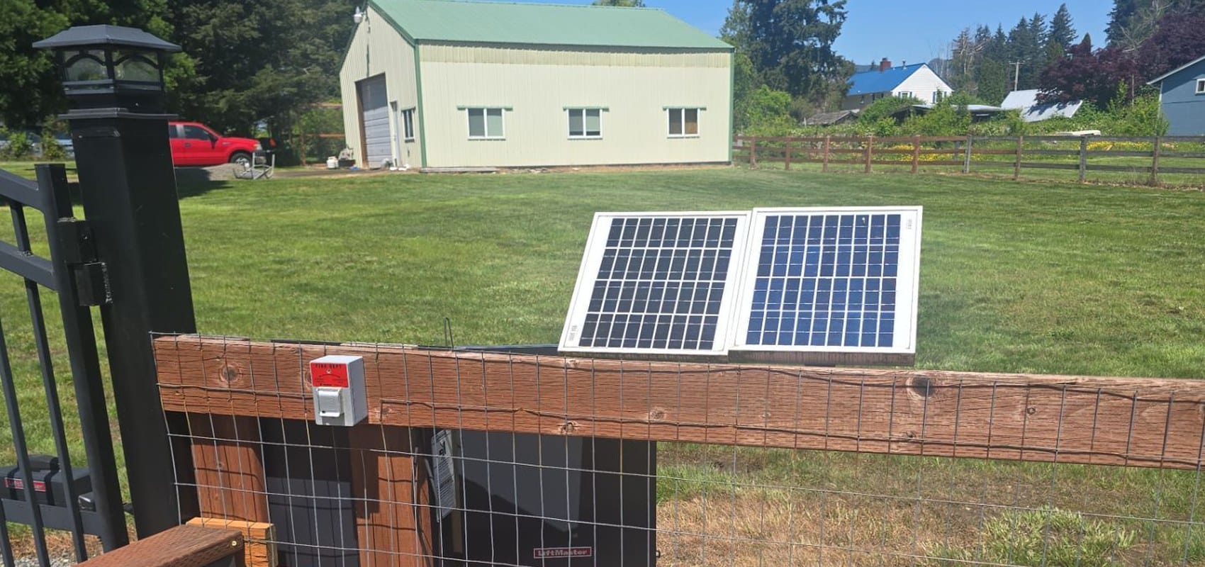 Solar panel mounted on a fence powering an automatic gate operator